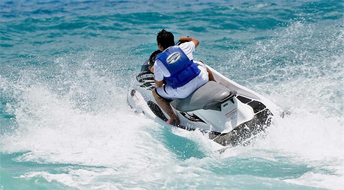 Un conducteur de jet-ski fonce sur la mer bleue.