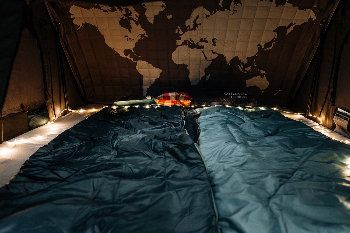 Innenaufnahme vom Dachzelt Skycamp 3.0 mit Schlafsäcken und Lichterkette