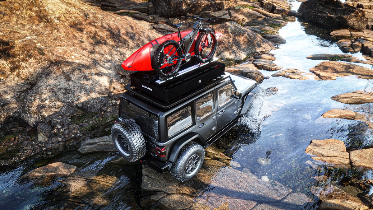 Un véhicule tout-terrain avec une tente de toit traverse une rivière