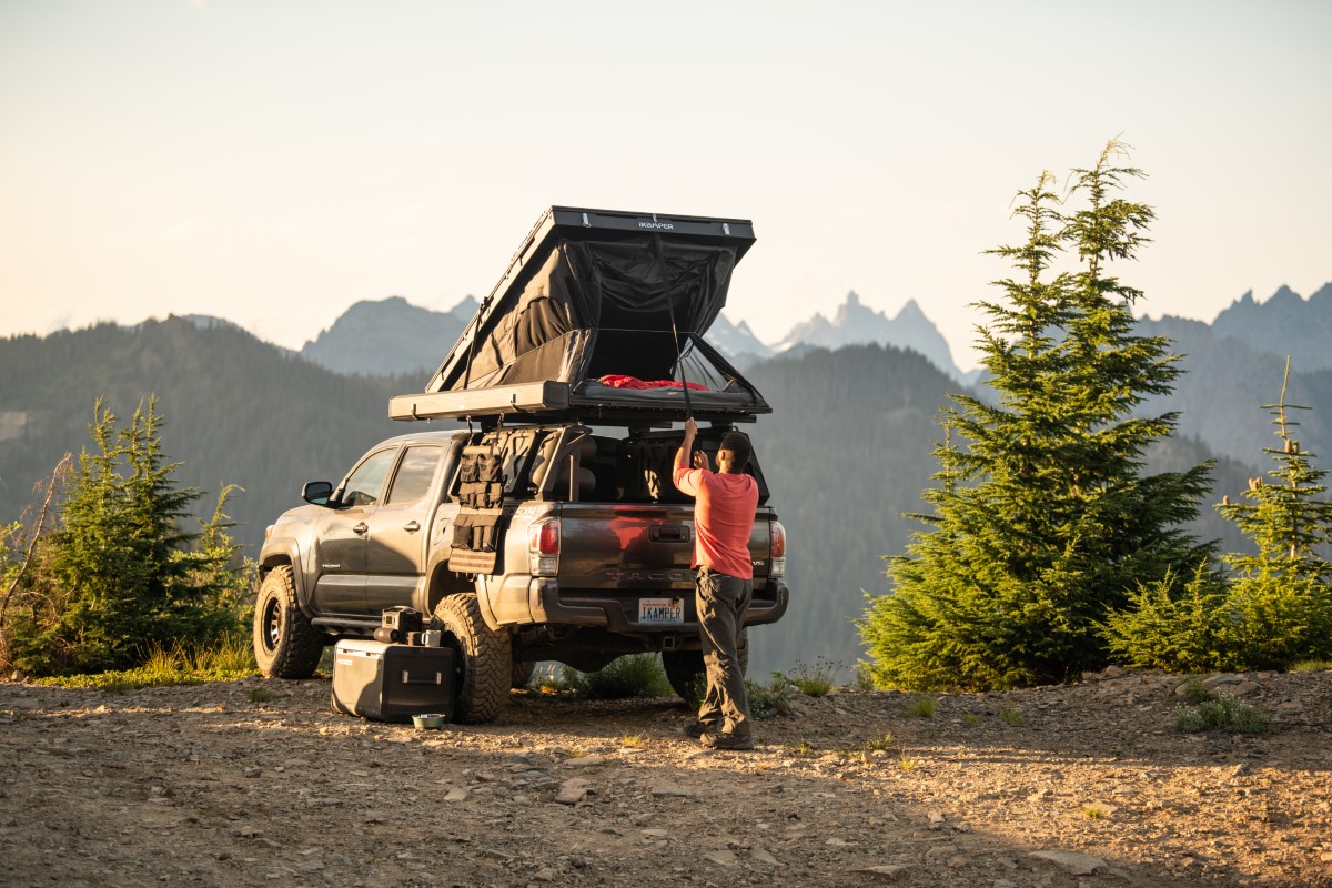 Un homme ferme la tente de toit sur son Toyota Hilux