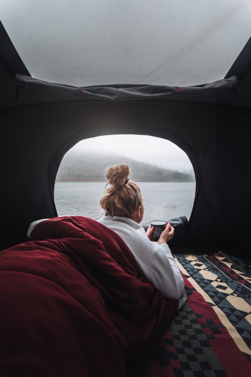 Une femme savoure une tasse de thé dans une tente de toit sur le T6