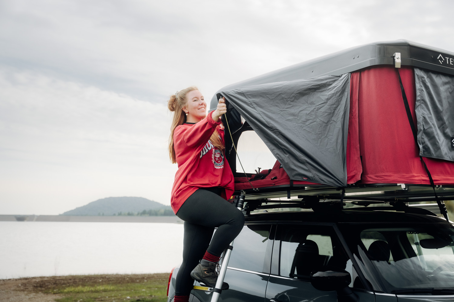 Une femme ferme sa tente de toit