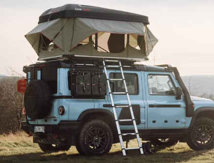 Tente de toit à coque rigide Good Vibes sur une voiture bleu clair dans les montagnes